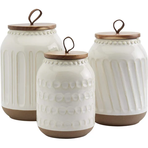 Tabletops Gallery Ceramic Canister Set with Wood Lids: textured white ceramic canisters with wood lids. flour, sugar, coffee, sorted.